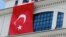 FILE - A Turkish flag is hung from the headquarters of Turkey's ruling Justice and Development party party, in Ankara, Turkey, March 20, 2013.