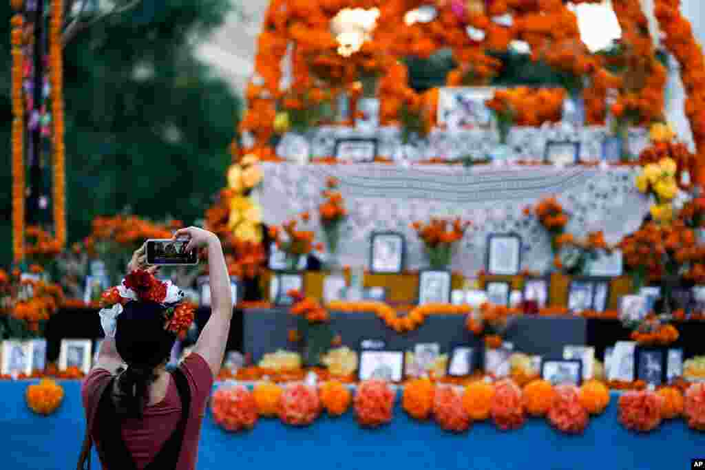 En EE.UU. tambi&#233;n se conmemor&#243; la fecha. Una mujer toma una foto de un altar del D&#237;a de Los Muertos en Grand Park, Los &#193;ngeles. Noviembre 1, 2020. 