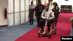 Bobi Wine is seen in a wheelchair just before his departure at Entebbe International Airport, in Entebbe, Uganda, Aug. 31, 2018 in this still image taken from a social media video on September 1, 2018. 