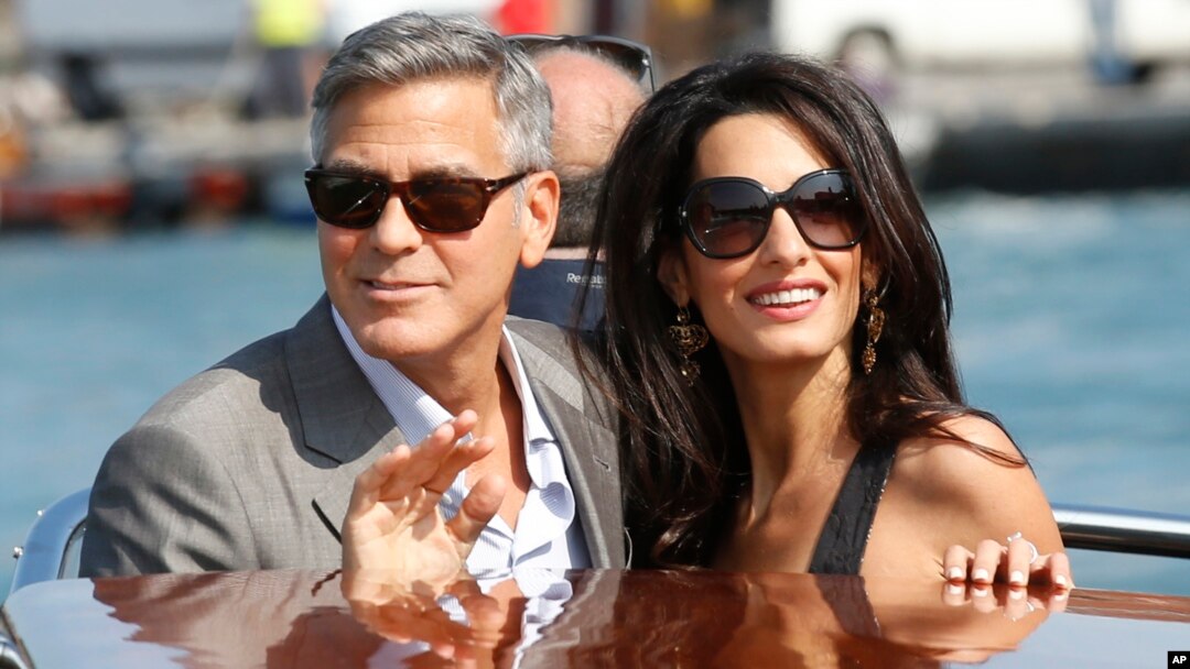 George Clooney, left, and Amal Alamuddin arrive in Venice, Italy, Sept. 26, 2014. 