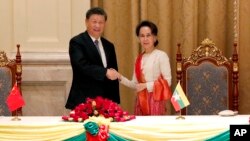 Pemimpin Myanmar Aung San Suu Kyi (kanan) dan Presiden China Xi Jinping (kiri) berjabat tangan usai penandatangan nota kesepahaman di istana kepresidenan, di Naypytaw, Myanmar, Sabtu, 18 Januari 2020. (Foto: AP)