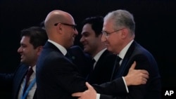 Mukhtar Babayev, COP29 President, right, embraces Simon Stiell, United Nations climate chief, after gaveling a deal for money to curb climate change at the COP29 U.N. Climate Summit in Baku, Azerbaijan, Nov. 24, 2024.