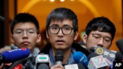 Pro-democracy activist Alex Chow, center, speaks to reporters outside the Court of Final Appeal in Hong Kong, Feb. 6, 2018. Hong Kong's highest court Tuesday overturned prison sentences for three young pro-democracy activists convicted for their roles in 