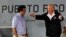 FILE - U.S. President Donald Trump talks with Puerto Rico Governor Ricardo Rossello (L) as they take their seats for a briefing on hurricane relief efforts in a hangar at Muniz Air National Guard Base in Carolina, Puerto Rico, Oct. 3, 2017.