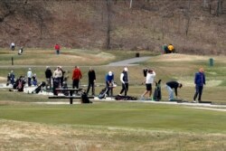 Golfers hit the driving range at Braemar Golf Course in Edina, Minn., April 20, 2020, following the weekend lifting of some stay-at-home order restrictions.