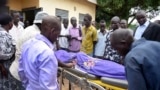 Relatives and onlookers watch as the body of South Sudanese journalist Peter Moi is taken into a mortuary in Juba, South Sudan, Aug. 20, 2015.