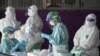 Para petugas medis mengumpulkan sampel hasil tes swab COVID-19 para pekerja migran di tengah perebakan pandemi di provinsi Samut Sakhon, Thailand (foto: dok). 