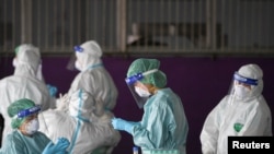 Healthcare workers get ready to collect samples during proactive testing of migrant workers at their work place, amid the spread of the COVID-19 outbreak in Samut Sakhon province in Thailand, Jan. 27, 2021.