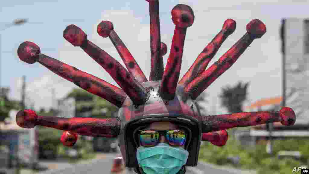 인도네시아 동 자바의 모조케르토에서 신종 바이러스를 형상화한 헬멧을 착용한 경찰관이 근무를 서고 있다. 