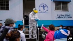 Una mujer recibe un resultado tras hacerse una prueba de COVID-19 en un puesto del Ministerio de Salud en Ciudad de Guatemala, el miércoles 25 de agosto de 2021.