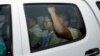 Ny Chakrya, center, former ADHOC and a National Election Committee member who worked at the organization, sits in a car and is transported back to an Anti-Corruption Unit, ACU, after a short appearance at Phnom Penh Municipal Court, in Phnom Penh, Cambodia, Saturday, April 30, 2016. Cambodian authorities arrested five human rights workers last Friday on accusations they tried to help cover up a woman's affair with the deputy leader of the opposition Cambodia National Rescue Party. The action is the latest in a series by Prime Minister Hun Sen's government putting legal pressure on its critics and political opponents. (AP Photo/Heng Sinith)