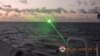 A green light appears from the direction of a Chinese coast guard ship at the Second Thomas Shoal, 105 nautical miles off the Palawan Province, Philippines, February 6, 2023 in this handout image. Philippine Coast Guard/Handout via REUTERS