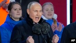 Presiden Rusia Vladimir Putin memberi isyarat saat berpidato di depan orang banyak dalam rangka kemenangannya dalam pemilihan presiden dan peringatan 10 tahun aneksasi Krimea oleh Rusia di Lapangan Merah di Moskow, Rusia, 18 Maret 2024. (Foto: AP)