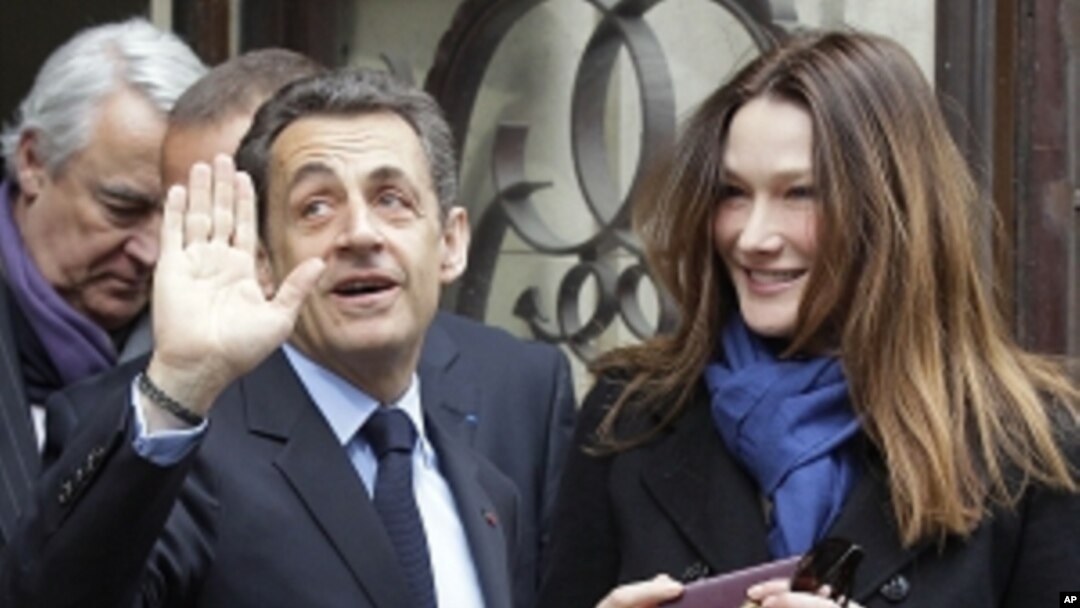 French President and UMP candidate Nicolas Sarkozy and his wife Carla Bruni-Sarkozy leave after casting their votes in the first round of French presidential elections in Paris, France, Sunday, April 22, 2012.