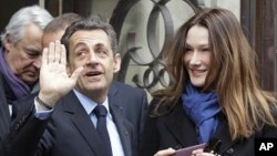 French President and UMP candidate Nicolas Sarkozy and his wife Carla Bruni-Sarkozy leave after casting their votes in the first round of French presidential elections in Paris, France, Sunday, April 22, 2012.