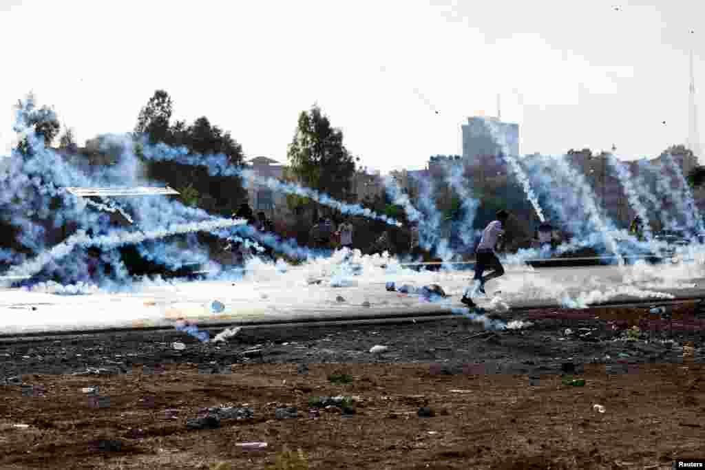 A man runs as Palestinians clash with Israeli troops during a protest near the Jewish settlement of Beit El, near Ramallah, in the Israeli-occupied West Bank.