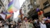 FILE - Demonstrators march with rainbow flags as they try to gather for a Pride parade, which was banned by local authorities, in central in Istanbul, Turkey, June 26, 2021.