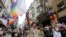 FILE - Demonstrators march with rainbow flags as they try to gather for a Pride parade, which was banned by local authorities, in central in Istanbul, Turkey, June 26, 2021.