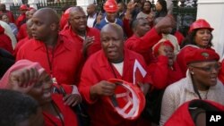 Julius Malema, center, leader of the Economic Freedom Fighters (EFF) party stands outside Parliament after he and party members heckled South African President Jacob Zuma, Cape Town, South Africa, Aug. 21, 2014.