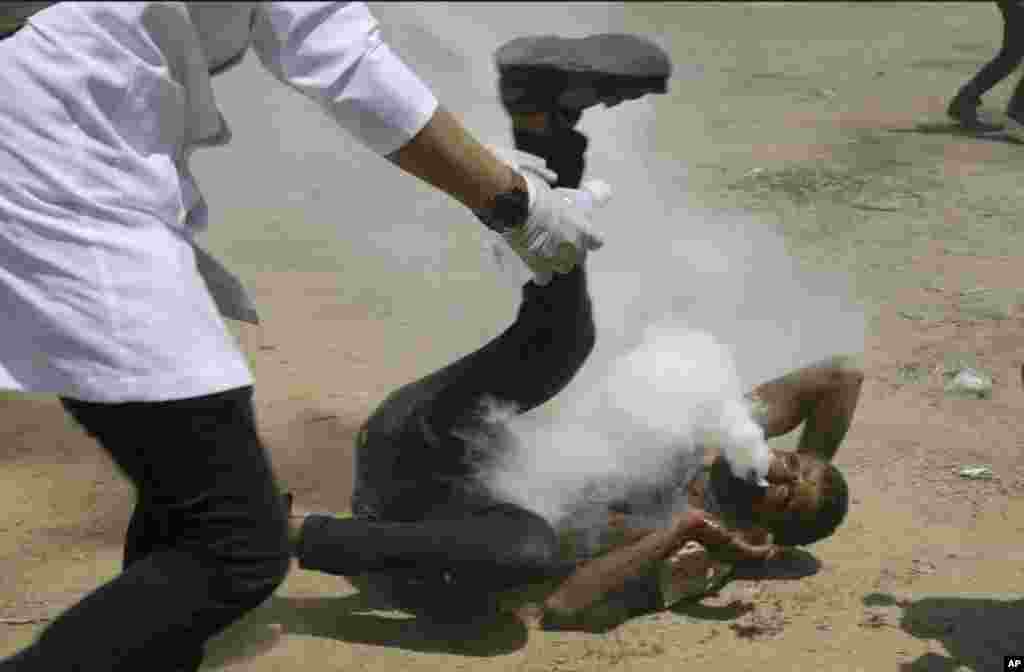 A Palestinian medic rushes to a a protester who got shot in his mouth by teargas canister fired by Israeli troops near the Gaza Strip&#39;s border with Israel, east of Khan Younis, June 8, 2018. Thousands of Palestinians are streaming toward the fence separating Gaza from Israel for a protest against the decade-long blockade of their territory.