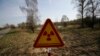 In this photo taken on Monday, April 11, 2016, a radiation warning sign is placed near the check-point 'Maidan' of the state radiation ecology reserve inside the 30 km exclusion zone around the Chernobyl nuclear reactor, some 370 km ( 231 miles) south-ea