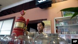 A bar tender pours beer for customers in Phnom Penh, Cambodia, file photo.