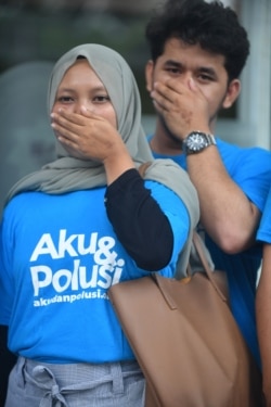 Indonesian environmental activists participate in a protest as they filed a lawsuit against Jakarta's toxic air pollution at the Central Jakarta court, July 4, 2019.