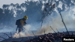 A firefighter battles a wildfire in Poway, California, Jan. 20, 2025. 