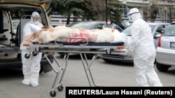 ARHIVA - Zdravstveni radnici u zaštitnim odelima prebacuju pacijenta obolelog od koronavirusa, 15. april 2020. (Foto: Reuters/Laura hasani)