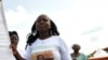 A supporter of Ivorian President Alassane Ouattara dances as she holds a banner reading in French "Peace and reconciliation" during a meeting on April 22, 2012 in Guiglo. 