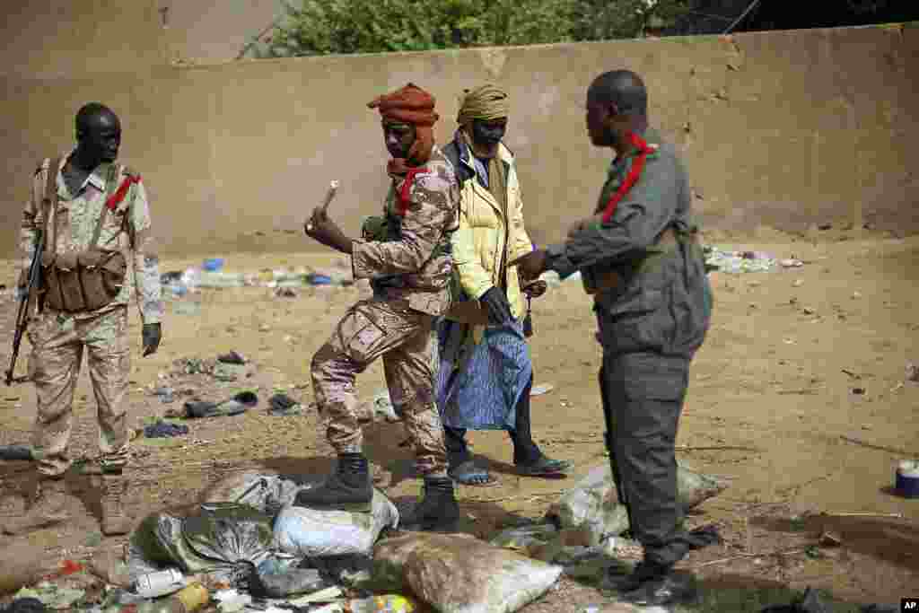 Malian soldiers inspect an explosive they found after residents notified authorities of suspicious bags left by radicals when they fled Gao, northern Mali, February 6, 2013. 