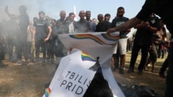 FILE - Para pengunjuk rasa anti-LGBTQ+ yang berhasil menerobos barikade polisi dan membakar tanda-tanda LGBTQ+ di area yang ditetapkan untuk Tbilisi Pride Fest, di Tbilisi, Georgia, 8 Juli 2023.