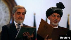 Presiden baru Afghanistan Ashraf Ghani Ahmadzai (kanan) dan kepala eksekutif Afghanistan Abdullah Abdullah mengambil sumpah dalam pelantikan di Kabul (29/9). 