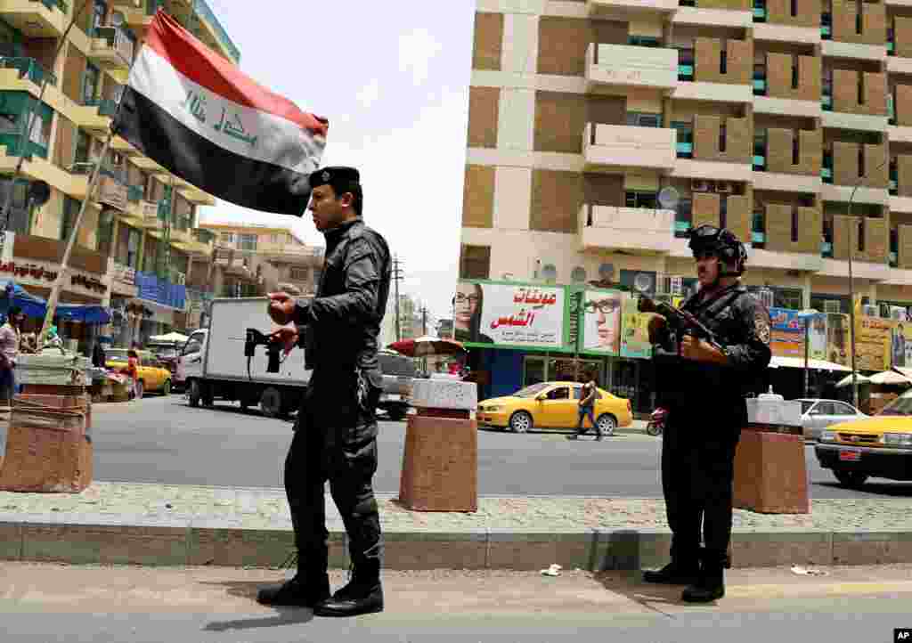 Polisi berjaga-jaga di sebuah pos pemeriksaan di Baghdad (11/6). (AP/Karim Kadim)