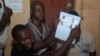 Election workers count legislative ballots after the close of voting, at a polling station in Conakry, Guinea, Sept. 28, 2013. 