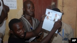 Election workers count legislative ballots after the close of voting, at a polling station in Conakry, Guinea, Sep. 28, 2013. 