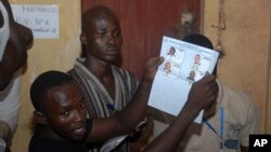 Le personnel électoral d’un bureau de vote à Conakry, dépouillant les bulletins après la clôture du scrutin, en Guinée, le 28 septembre 2013.