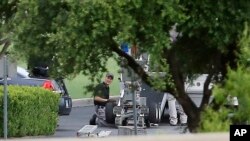 FILE - Police appear to set up a remotely operated robot during a stand-off with a gunman barricaded inside a van at a Jack in the Box restaurant in Hutchins, Texas. 