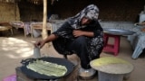 FILE: Eman Mohamed, 20, a Sudanese woman who fled the violence in Sudan's Darfur region, prepares what she said is Konafa for breakfast, at the yard of a Chadian's family house where she takes refuge, near the border between Sudan and Chad in Koufroun, Chad, on May 14, 2023.