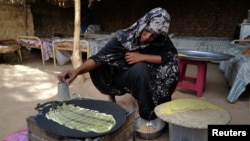 FILE: Eman Mohamed, 20, a Sudanese woman who fled the violence in Sudan's Darfur region, prepares what she said is Konafa for breakfast, at the yard of a Chadian's family house where she takes refuge, near the border between Sudan and Chad in Koufroun, Chad, on May 14, 2023.