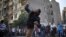 A protester throws stones at riot police during clashes at Tahrir square in Cairo, November 26, 2012.