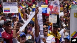 Varias personas sostienen actas de recuento de votos durante una protesta contra los resultados oficiales que declararon al presidente Nicolás Maduro ganador de las elecciones presidenciales, en Bogotá, Colombia, el sábado 17 de agosto de 2024. (Foto AP/Matias Delacroix)