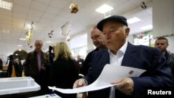 Former mayor of Moscow Yuri Luzhkov casts his ballot at a polling station during a parliamentary election in Moscow, Russia.