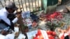 People approach an injured man with a gunshot wound amid protests against the military coup in Yangon, Myanmar, February 28, 2021, in this still image from video obtained via social media. (Credit: Myanmar Now)