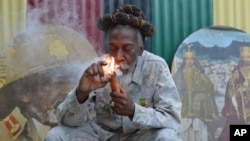 FILE - In this Aug. 28, 2014 file photo, legalization advocate and reggae legend Bunny Wailer smokes a pipe stuffed with marijuana during a “reasoning” session in a yard in Kingston, Jamaica. 