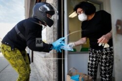 Melanie Milano, left, delivers a shipment of personal protective equipment to Doctor Yelena Malina at her practice in the Coney Island neighborhood of the Brooklyn borough of New York, May 3, 2020.