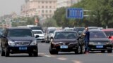 A man waits after being involved in a traffic accident as drivers pass him in heavy traffic on a road in Beijing, China.