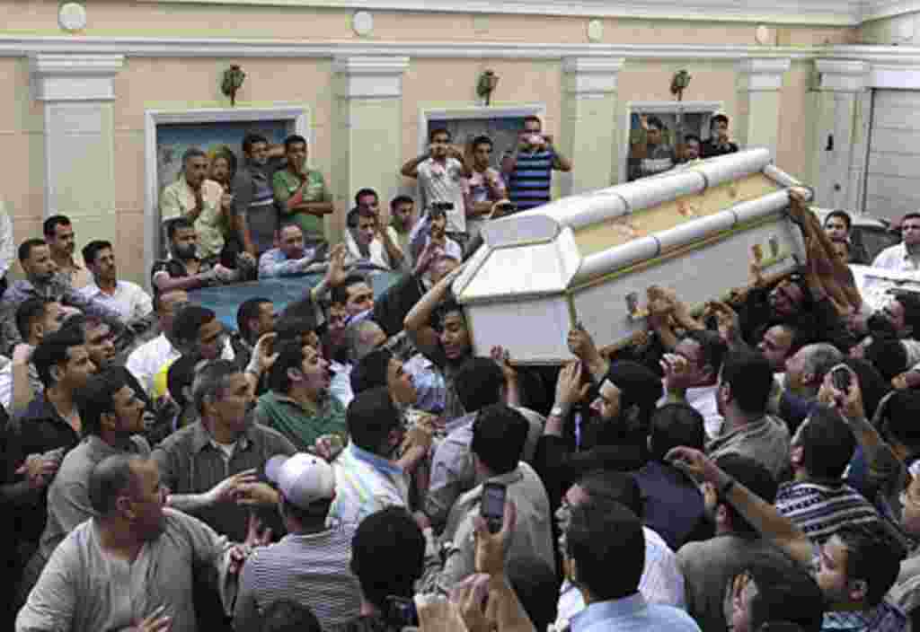 Egyptian Christians carry the coffin of one of the victims of Saturday night's clashes with Muslims in the streets western Cairo, during a funeral ceremony at Giza church Sunday, May 8, 2011