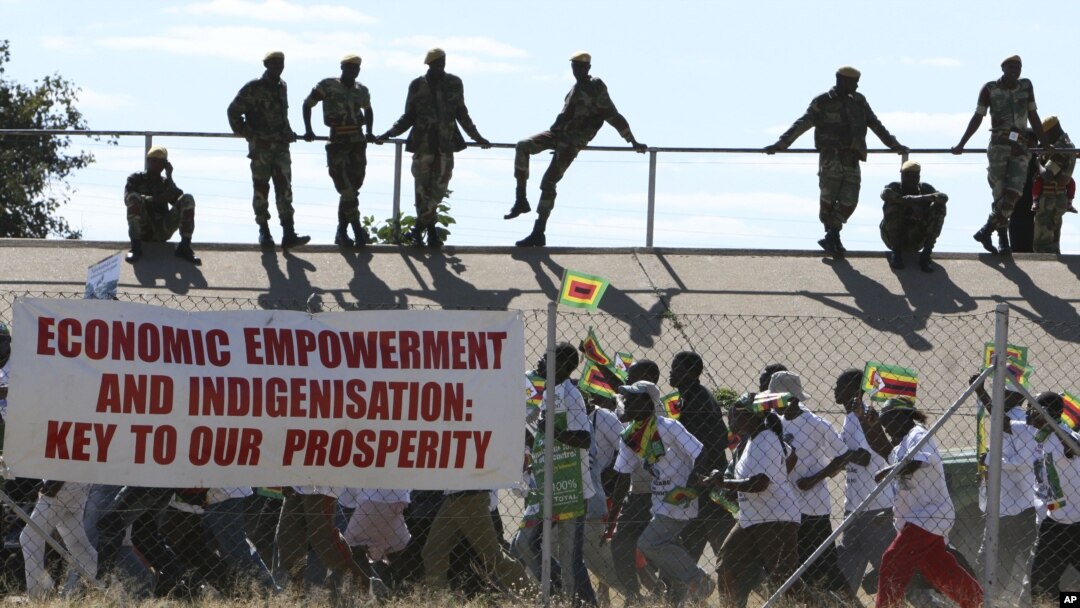 Zimbabwean soldiers look on as Zanu PF youths march for President Robert Mugabe at a rally in Bulawayo, June 20, 2008. 