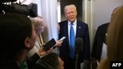 U.S. President Donald Trump speaks with journalists on Air Force One, en route to the White House in Washington, Feb. 19, 2025.